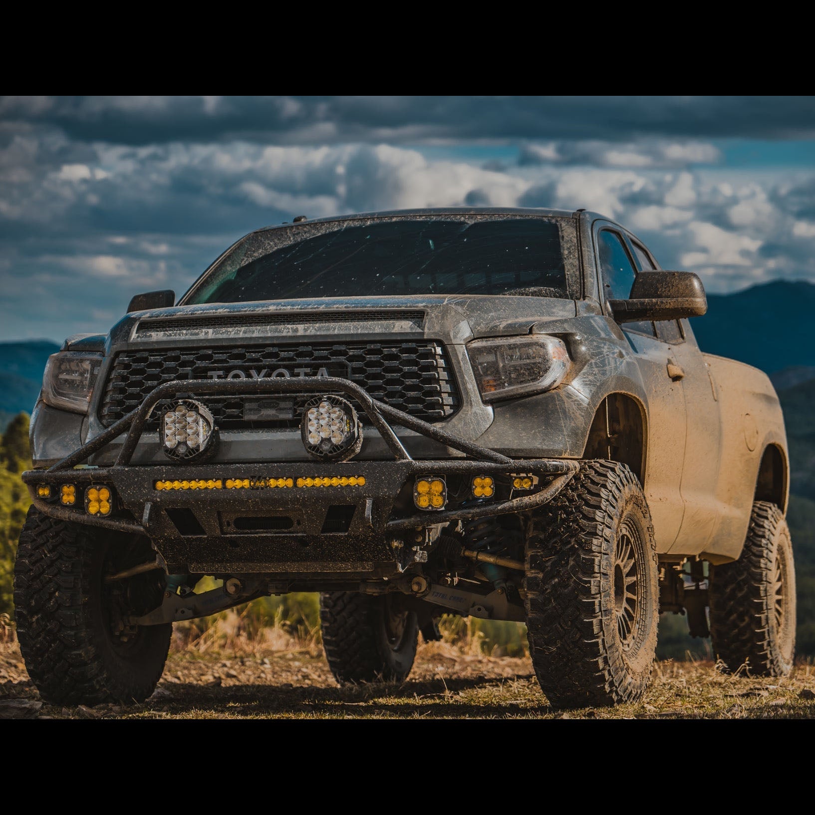 Close view of the C4 Hybrid bumper installed on a lifted 2014+ Toyota Tundra Double Cab with widebody fenders and fully-equipped with aftermarket LED lighting.
