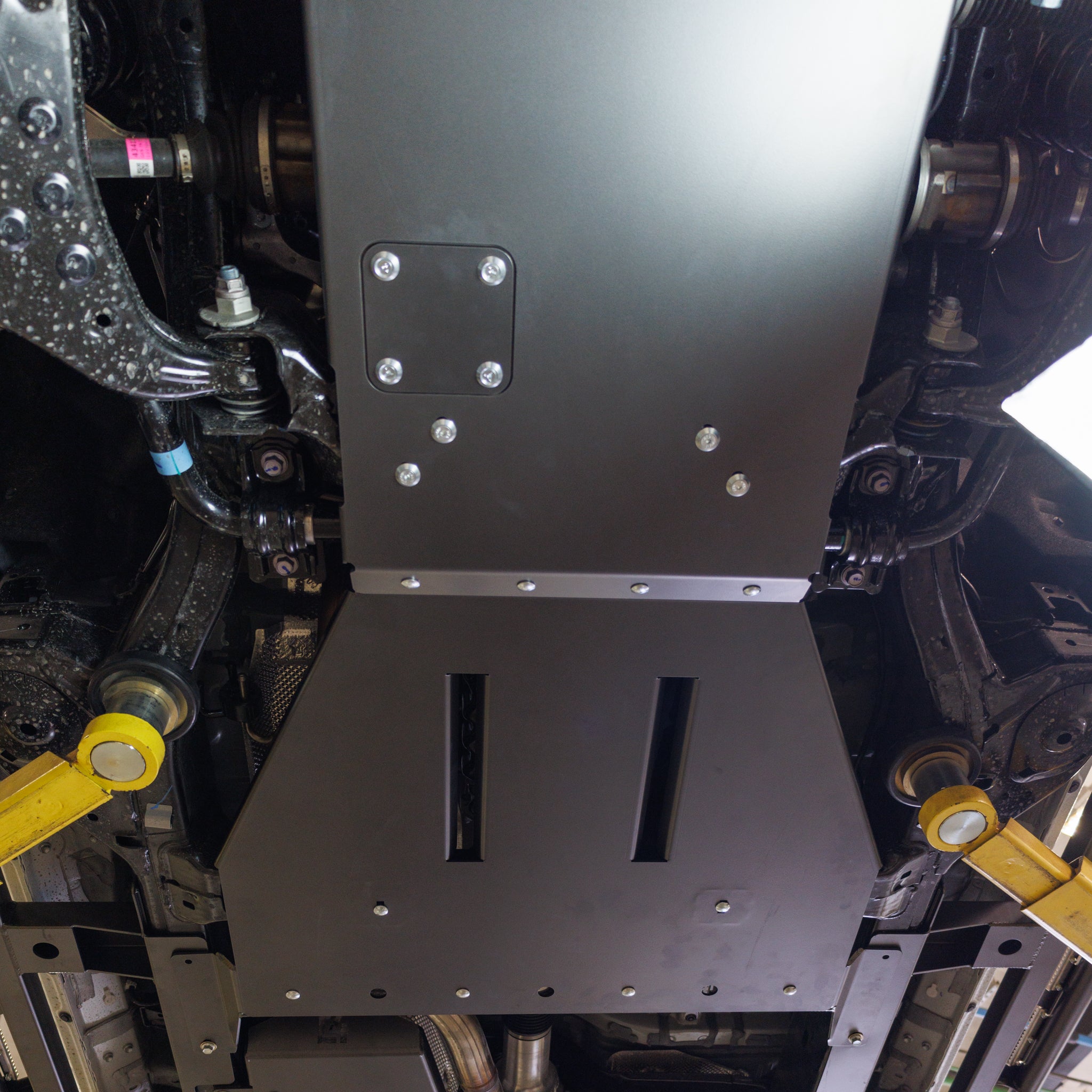 View of the C4 rear skid plates for the Land Cruiser LC250 from underneath, showing protection for the transmission, transfer case and exhaust including the catalytic converter. 