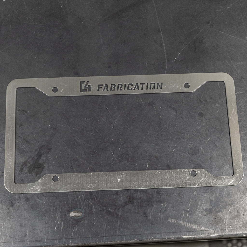 C4 License Plate Frame layed flat on a steel table to show the surface finish ready to be scuffed, polished or painted. 