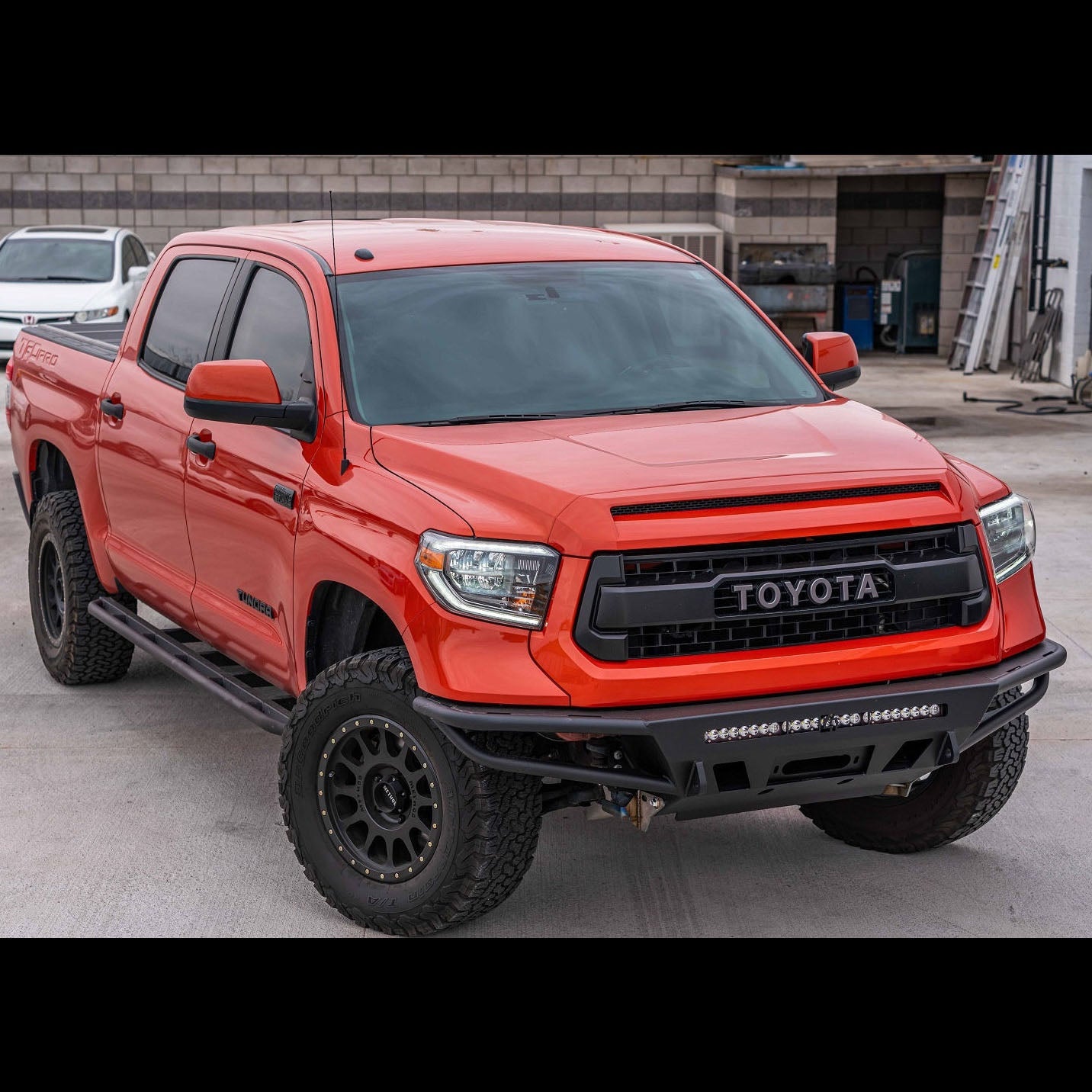 C4 Hybrid bumper installed on a red Toyota Tundra CrewMax.