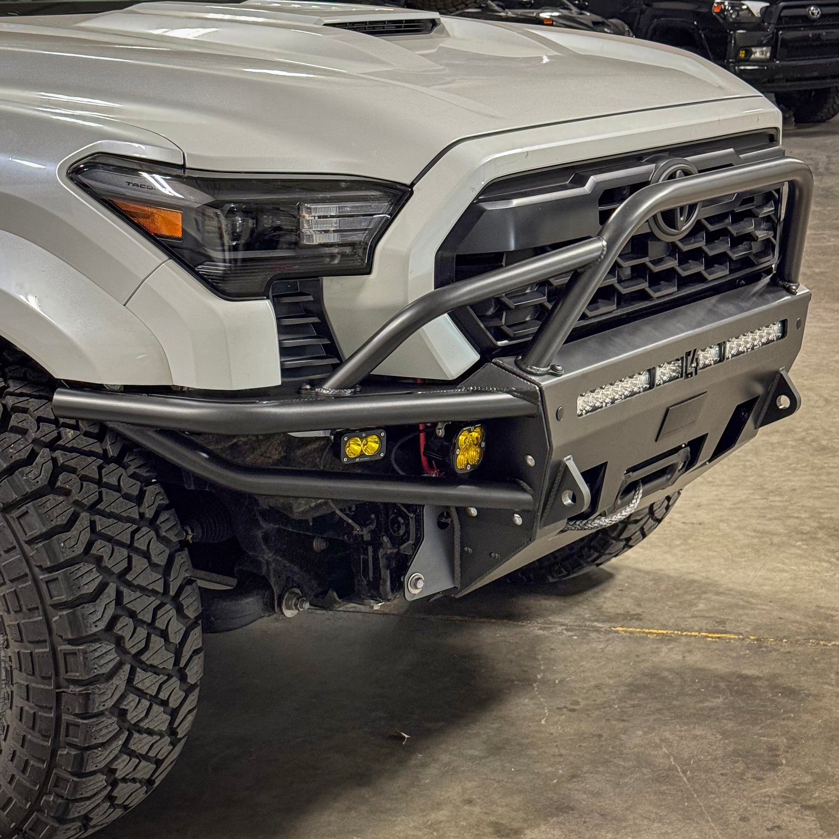 Passenger side view of the Hybrid bumper from C4 for Toyota Tacomas 2024 and newer, installed on a white Tacoma.