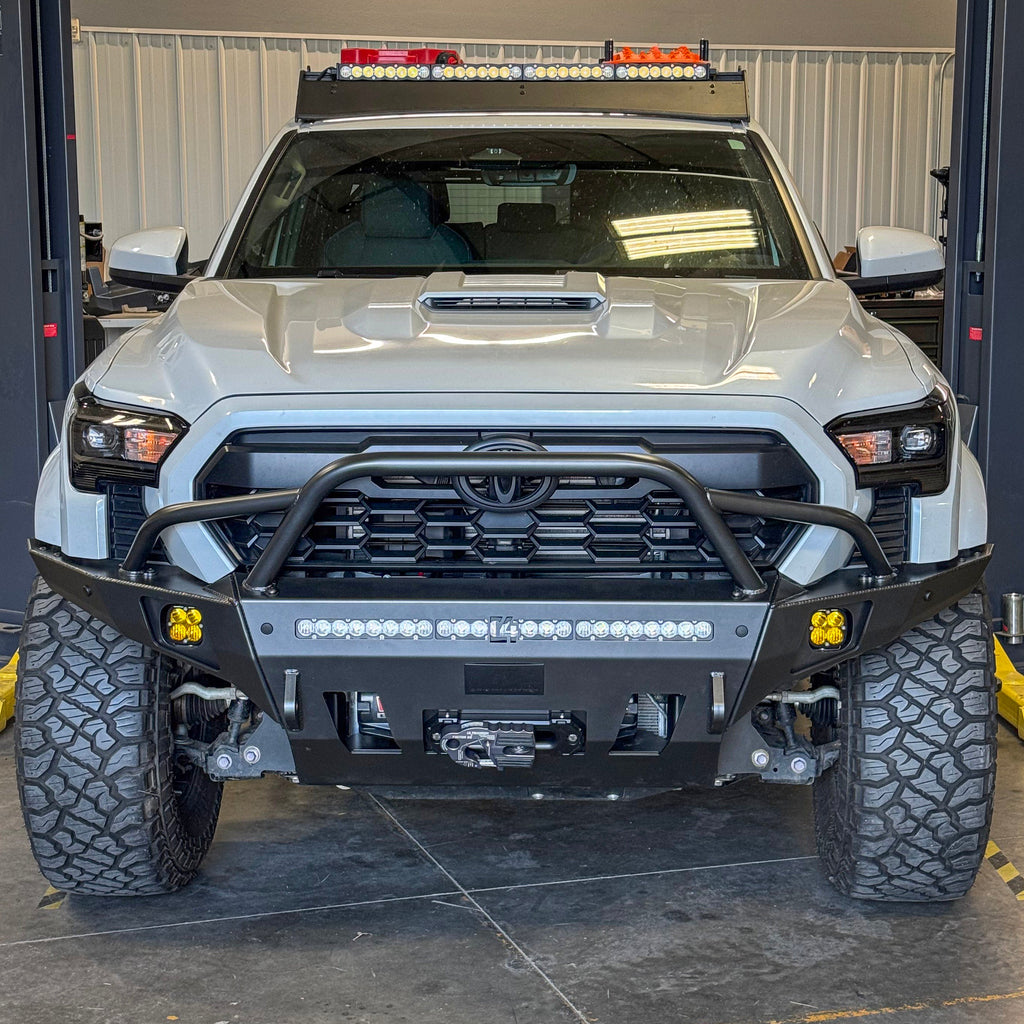 C4 Fabrication winch bumper on a white 2024 Tacoma showing off the mid-height bull bar with tube gussets. 