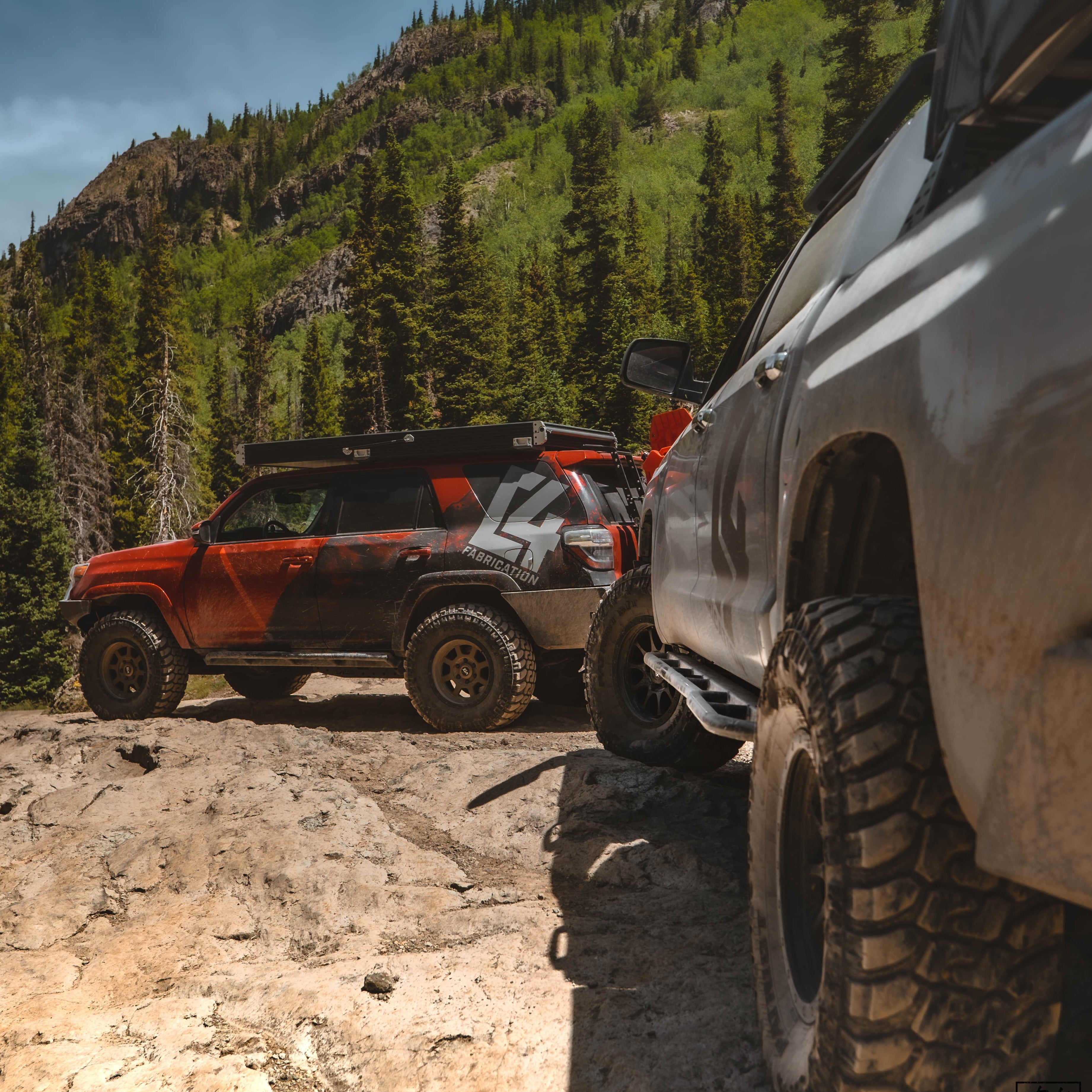 Quartering away shot of the C4 Tundra on a trail ride with a 5th Gen 4Runner and showing off the prototype Tundra rock slider from C4 Fabrication.